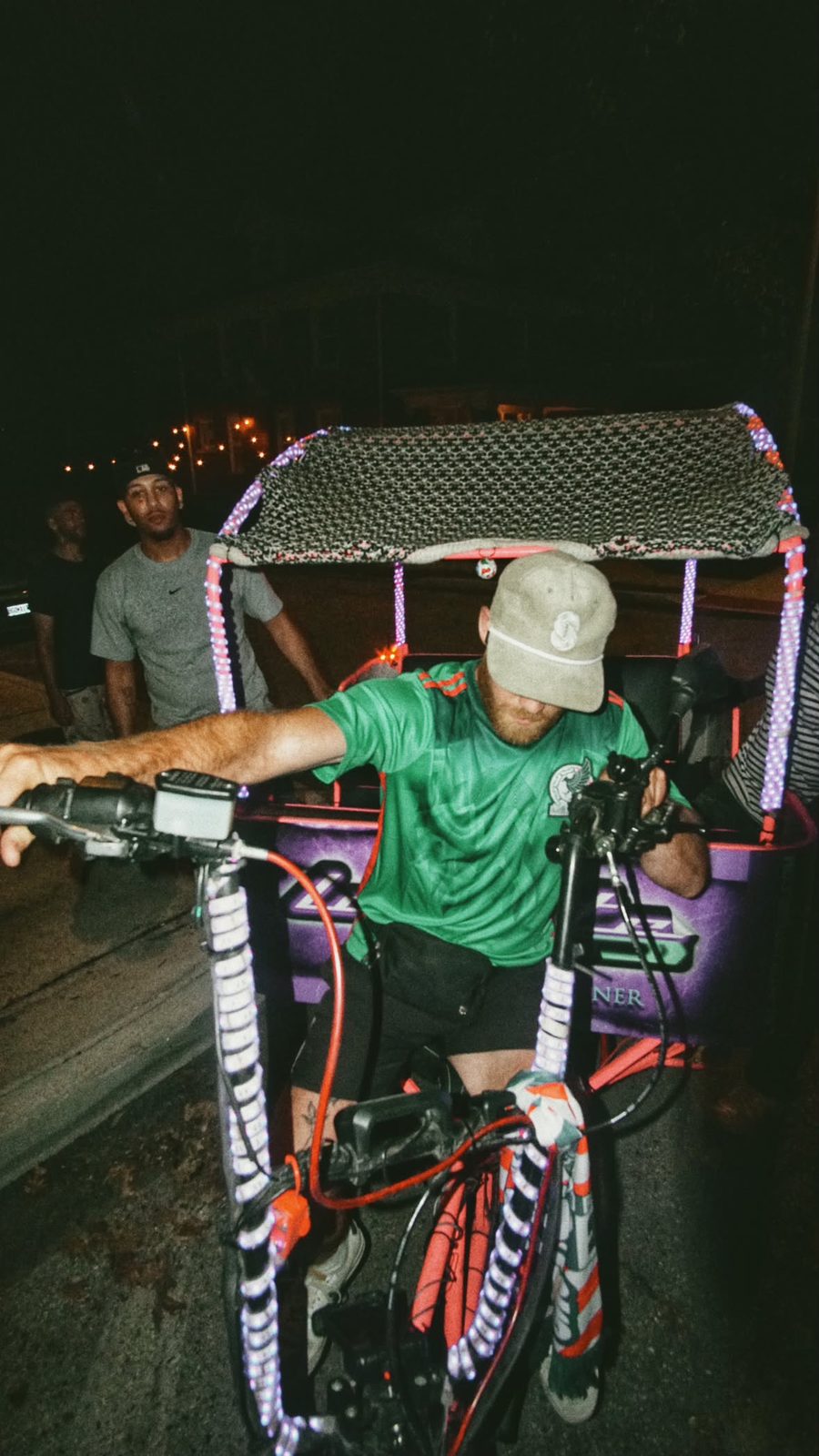 EZ driver with a lit-up pedicab at night
